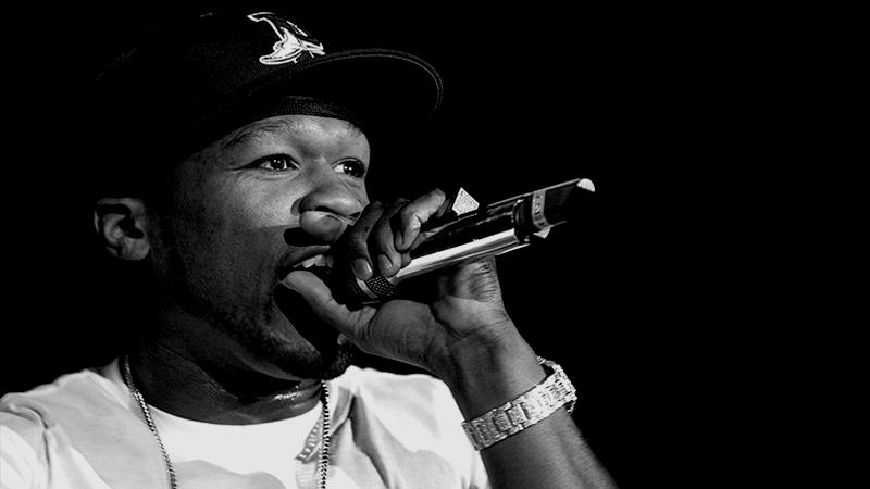 50 Cent rappt in ein Mikrofon in Schwarzweiß