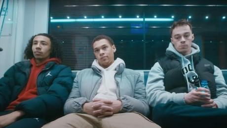 Drei Jungs sitzen in einer Bahn.